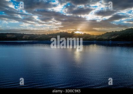 The sun's rays break through the clouds, illuminating the water and creating a stunning natural landscape Stock Photo