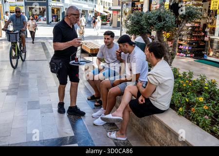 A Man Serving Turkish Tea To People In The Street, Marmaris, Mugla Province, Turkey. Stock Photo