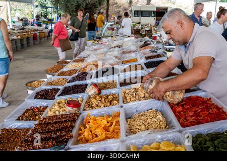 A Local Man Organises His Dried Fruit and Nuts Stall At The Monday Market In The Town of Turunc, Mugla Province, Turkey. Stock Photo