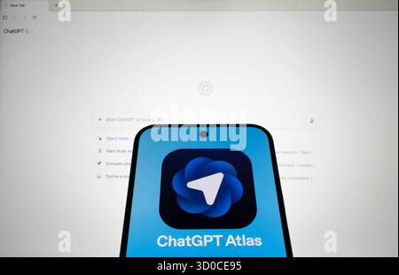 ChatGPT Atlas logo on smartphone with actual OpenAI Atlas browser interface on computer screen. Stafford, United Kingdom, October 22, 2025 Stock Photo