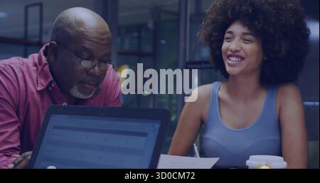 Reviewing documents by man in pink shirt and woman in blue at office, with laptop, coffee Stock Photo