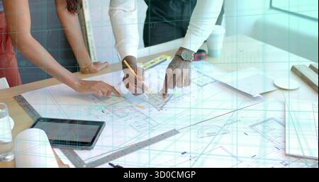 Pointing two architects leaning over wooden table in design studio, with blueprints pencil tablet Stock Photo