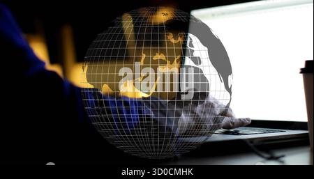 Typing hands in blue shirt on laptop keyboard at desk, with globe overlay and coffee cup Stock Photo