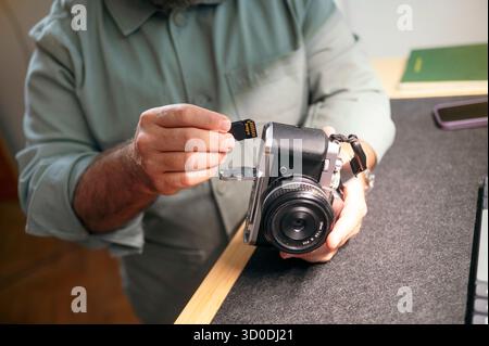 Man inserting memory card into camera. Stock Photo