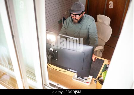 Man standing at desk working on computer. Stock Photo