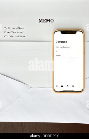 Memo document with envelope and smartphone displaying blank email compose screen, concept for business communication, digital correspondence, office m Stock Photo