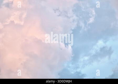 A serene sky scene featuring a patchwork of soft blue, pale pink, and grey cumulus clouds, suggesting the delicate colors of twilight, dawn, or sunset Stock Photo