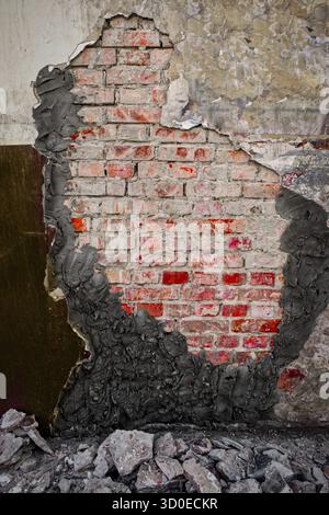 Demolished plaster over worn wall with new cement plaster partially covering gap Stock Photo