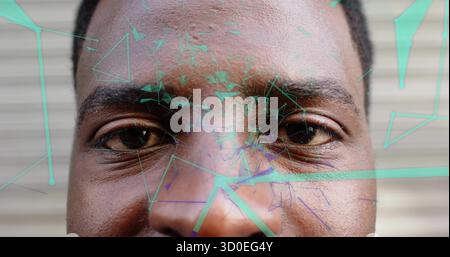 Overlaying network lines across adult man's face at slatted wall, with aqua-green and purple nodes Stock Photo