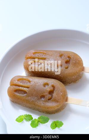 Homemade apple lemon mint popsicles isolated on a white plate Stock Photo