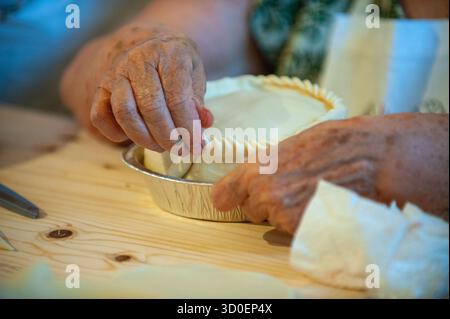 Hands crimping and sealing the edge of a sa panada, traditional Sardinian stuffed pastry, at the Sagra de sa Panada, Assemini, Sardinia, Italy Stock Photo