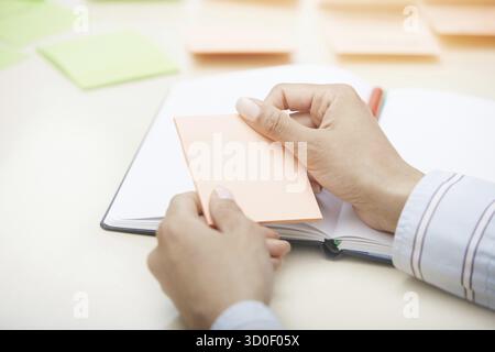 Hands holding sticky note with empty space Stock Photo
