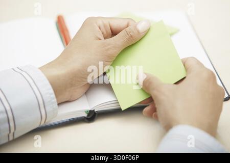 Hands holding sticky note with empty space Stock Photo