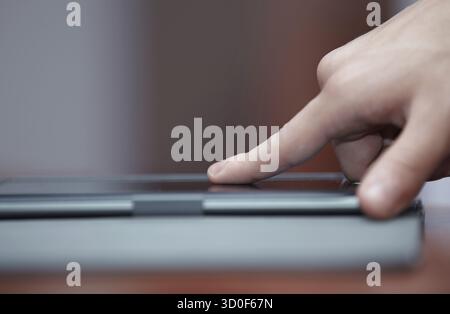 Human hand using tablet computer indoors Stock Photo