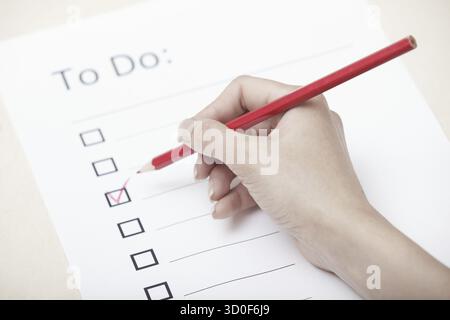 Human hand writing on a checklist document Stock Photo