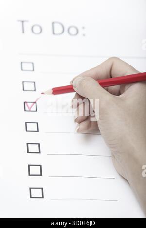Human hand writing on a checklist document Stock Photo