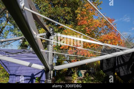 Rotary washing line including washing, pegs and wash basket on a sunny day Stock Photo