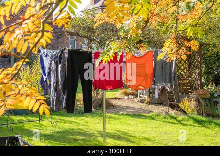 Rotary washing line including washing, pegs and wash basket on a sunny day Stock Photo
