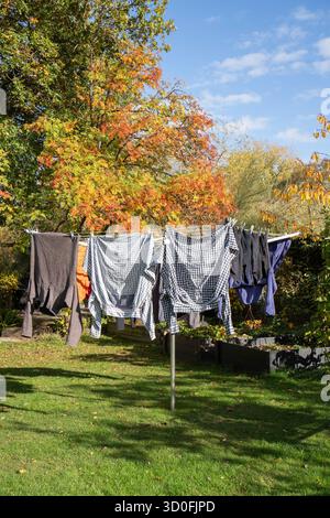 Rotary washing line including washing, pegs and wash basket on a sunny day Stock Photo