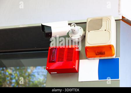 Alarm devices and a video camera hanging on the wall of the building Stock Photo
