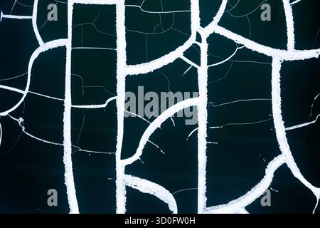 Background in the form of white wide cracks on a black background Stock Photo