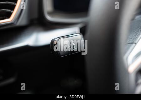 New car headlights control and adjustment lever behind the steering wheel. Close up shot shallow depth of field, no people Stock Photo