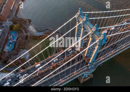 Aerial view of the majestic Manhattan Bridge spans the East River, its steel cables gleaming in the afternoon sun, connecting bustling shores, Manhattan, New York, United States. Stock Photo