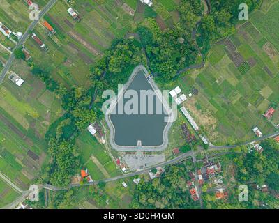 Aerial view of a reservoir surrounded by agricultural fields and lush greenery, a tranquil scene of nature's embrace, Yogyakarta, Daerah Istimewa Yogyakarta, Indonesia. Stock Photo