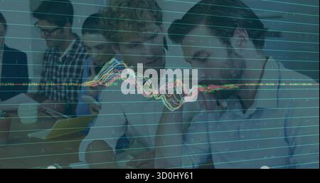 Collaborating colleagues pointing at tablet on conference table, with digital chart overlay Stock Photo