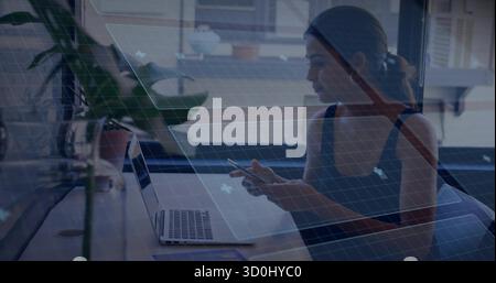 Holding smartphone woman wearing sleeveless top at office desk, with laptop and plant, copy space Stock Photo