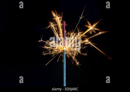 Burning sparkler on the black background, close up. Sparkler concept. Bengal lights on holiday party concept. New Year party sparkler Stock Photo