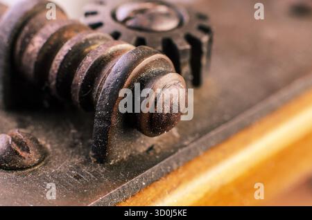 Extreme macro closeup of rusty worm gear and surrounding metal parts showing texture, wear, and industrial machinery detail. Stock Photo