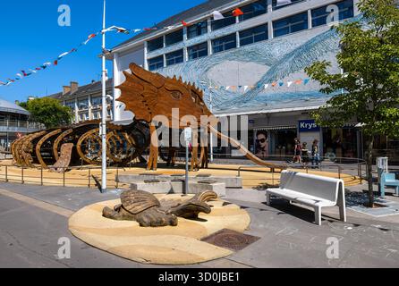 Saint Nazaire, France - August 4, 2025: Outdoor art installation in Saint Nazaire featuring a large wooden sea creature sculpture and a turtle statue Stock Photo