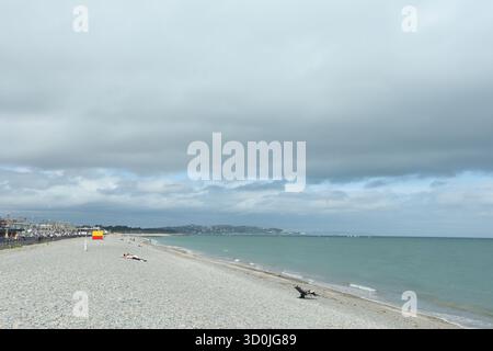 Bray, Wicklow, Ireland  -  10th August 2025 - A view of a stone covered beach in Bray in County Wicklow on an overcast afternoon with spells of sunshine in the seaside town facing the Irish Sea Stock Photo