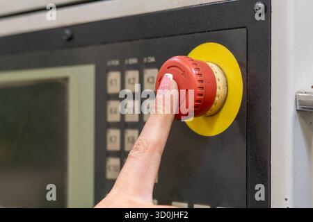 Red emergency stop button on an industrial control panel Stock Photo