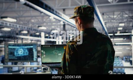 Army expert in data center integrating AI machine learning into radar systems for missile tracking. Military soldier in server farm analyzing aerial movement through neural networks systems, camera B Stock Photo