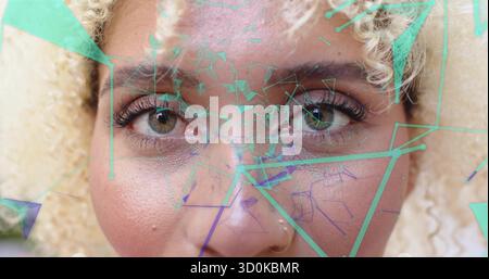 Showing woman's face with green and purple overlays in studio, highlighting silver nose stud Stock Photo