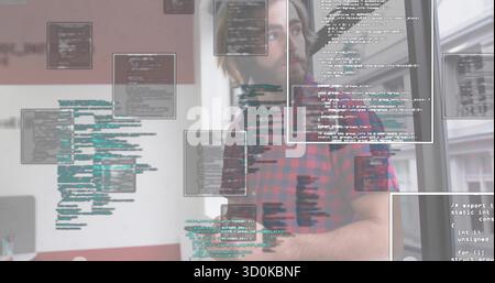 developer typing code at office desk wearing red flannel shirt with monitor and code overlays Stock Photo
