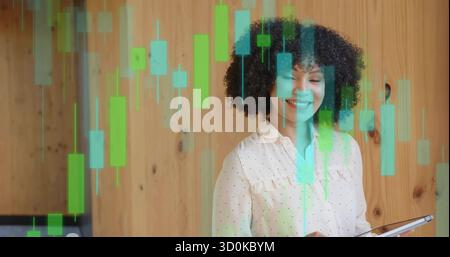 Smiling woman holding tablet analyzing candlestick charts in front of wood-paneled wall, copy space Stock Photo