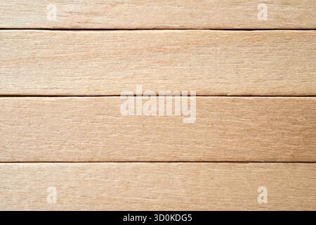 A light-colored wooden surface showcases smooth grain patterns. Ideal for crafts, furniture making, or home decor projects, the wood's natural beauty Stock Photo