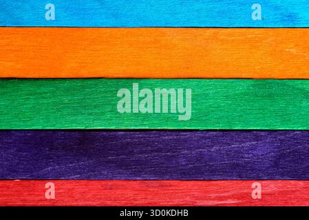 Brightly colored wooden planks in horizontal stripes create an inviting display. The arrangement features orange, blue, green, purple, and red, ideal Stock Photo