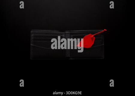 Black Friday concept with an open black wallet holds a red price tag on a dark background. Stock Photo