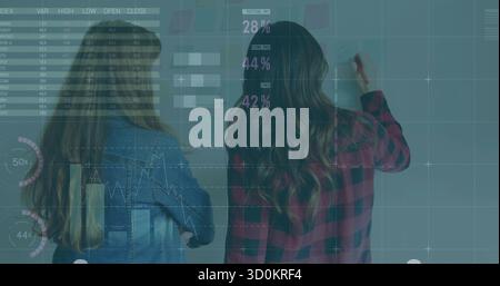 Collaborating two professionals writing data on conference glass wall, with marker and sticky notes Stock Photo