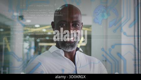 Smiling engineer wearing white shirt in modern office, with code and circuit board overlays Stock Photo