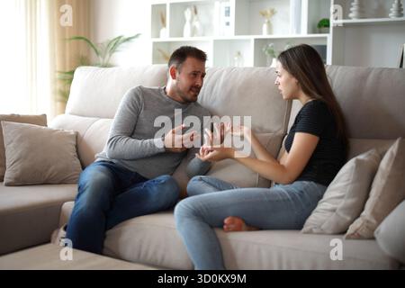 Sad couple arguing sitting on a couch at home Stock Photo