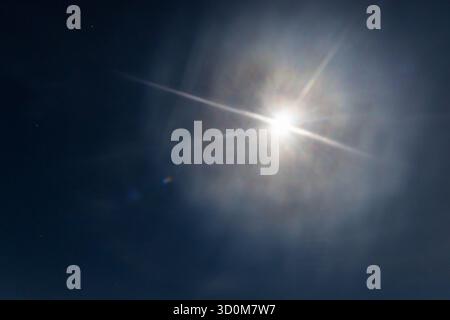 bright moon halo shining in clear blue sky Stock Photo
