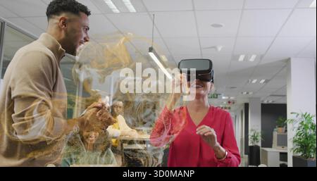 Hispanic woman in red blouse wearing VR headset using hologram in office meeting, copy space Stock Photo