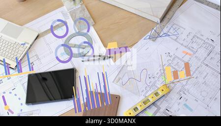 Showcasing tablet computer presenting charts and blueprints on architect desk, with compass, rulers Stock Photo