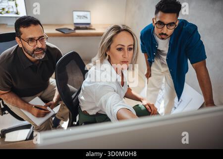 Three architects engaging in a creative discussion, showcasing teamwork and design process. Stock Photo
