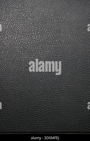 A close-up, full-frame texture of dark, pebbled or grained leather. A uniform surface suitable as a background or overlay. Stock Photo